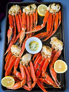 cooked lobsters on a tray with lemon wedges and garlic sauce, ready to be served