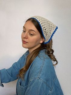 a woman wearing a white and blue crochet hat while using a sewing machine