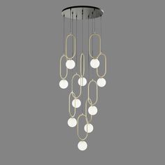 a modern chandelier with white balls hanging from it's center and gold chain