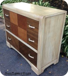 an old dresser has been painted with wood and is sitting in front of some bushes