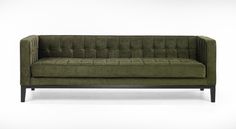 a green couch sitting on top of a white floor