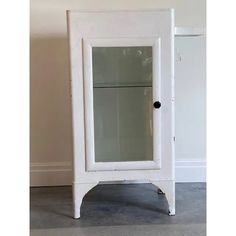 a white cabinet with glass doors on the bottom and one door open to reveal a mirror