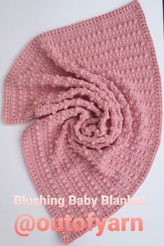 a pink crocheted knitted baby blanket with a knot on the end and text reading, bluishing baby blanket