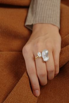 Introducing our stunning Baroque Pearl Ring, featuring a beautiful combination of White Large Baroque Pearl and Keshi Pearl. The unique irregular shape of the pearls creates a mesmerizing effect, making this ring a true standout piece. Crafted with high-quality materials, this ring band is made with 14K gold plating, ensuring its durability and long-lasting shine. The ring is also adjustable, making it easy to find the perfect fit for your finger. (If your ring size is smaller than US7, please make a note and I will include a free rubber size adjuster) This Oversized Ring is perfect for those who love minimalist jewelry that still makes a statement. Whether you're dressing up for a special occasion or adding a touch of elegance to your everyday look, this Baroque Pearl Ring is sure to impr Adjustable Gold Pearl Ring, Faux Pearl Rings, Oversized Ring, Jewelry Aesthetic, Kesha, Ring Minimalist, Keshi Pearls, Ring Band, How To Make Notes