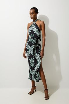 Bring In The Summer With Our Maxi Dress, With A Fit That Flatters The Curves, And A Statement Geometric Print. The Twisted Halter Neckline Elevates The Formality, While The Thigh High Leg Split Makes For A Statement Piece. It Is Adorned With Detailed, In-House Designed Print Work, And Can Easily Be Styled With A Pair Of Sandals Or Heels. Geo Printed Morocain Woven Maxi Dress High Quality Morocain Fabric Comfortable Figure Skimming Fit Unique Geometric Print Twisted Halter Neckline Thigh High Leg Elegant Sleeveless Patterned Dress, Bride Jumpsuit, Petite Wedding Guest Dresses, Latest Maxi Dresses, Plus Size Workwear, Summer Bridesmaid Dresses, Maxi Dress Collection, Leg Split, Outfits Petite