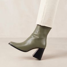 Green leather ankle boots with block heel Crafted from premium green leather, South is the ankle boot you’ll live in all season long. With their sassy block heel and gorgeous square toe, these '90s-inspired booties are a safe bet. Wear them all year round - in winter with chunky roll-neck and jeans, in summer with mini dresses or denim shorts. We guarantee that all your fashion ensembles will start and end on a pair of these! Olive Heels, Olive Boots, Vegan Boots, Sustainable Leather, 90s Inspired, Short En Jean, Roll Neck, Mini Dresses, Green Leather