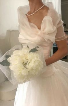 a woman in a wedding dress holding a bouquet