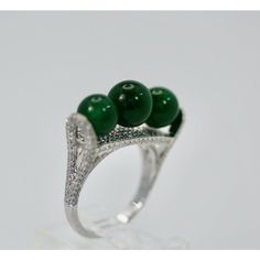 This is part of Chairish’s Fine Jewelry assortment.  Jadeite Bead and Diamond Ring  This gorgeous ring comes out of a Sotheby's Fine Jadeite and Jade auction in Hong Kong. It consists of three (3) Jadeite Beads 7.75 round on a Diamond surround and base. This ring is Jadeite, not Jade or Nephrite bit real Jadeite. These Beads glow are an intense green and translucent and it comes with a certificate from Hong Kong Jade stone Laboratory stating no resin is detected, a fine Fei Cui-type A dated 9/27 Elegant Formal Jade Rings, Elegant Jade Ring Jewelry, Elegant Jade Cabochon Rings, Elegant Jade Ring, Elegant Jade Rings With Cabochon, Elegant Emerald Jade Ring With Cabochon, Luxury Rings With Natural Stones, Elegant Silver Emerald Ring With Natural Stones, Elegant Green Emerald Ring With Stones