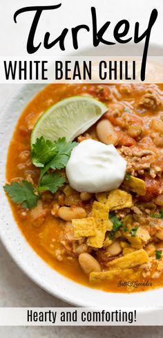 white bean chili in a bowl with sour cream and cilantro garnish