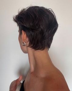 the back of a woman's head with short black hair and earrings on it