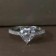 a heart shaped diamond ring on a table