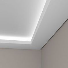 an empty room with white walls and a skylight in the ceiling is lit up