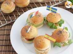 small sandwiches with flags on them sitting on a plate