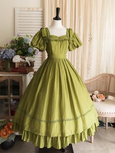 This price includes a dress and a green bowknot hairclip (not for sale).  Embrace timeless elegance with this enchanting Olive Green Puff Sleeves Classic Lolita Princess Tea-Length Dress. Designed for the true Lolita aficionado, this dress features delicately puffed sleeves and a flattering tea-length skirt that exudes sophistication and charm. The back boasts a comfortable shirring detail, ensuring a perfect fit for all body types. Whether you're attending a tea party, a cosplay event, or simpl Green Puff Sleeve Dress For Wedding, Green Puff Sleeve Dress In Cottagecore Style, Green Cottagecore Dress With Ruffles, Vintage Green Puff Sleeve Dress, Vintage Green Dress With Puff Sleeves, Green Vintage Dress With Ruffles For Garden Party, Green Vintage Victorian Dress With Ruffles, Vintage Green Square Neck Dress, Green Ruffled Vintage Dress