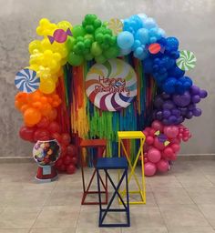 the balloon arch is decorated with balloons and streamers for a happy birthday party in rainbow colors