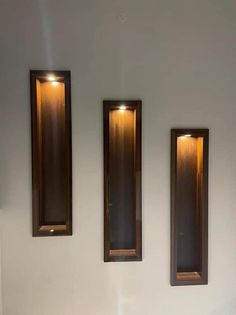 three wooden mirrors mounted to the wall above a sink