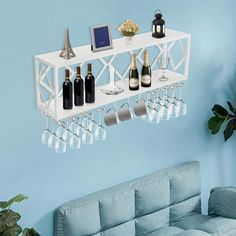 a living room with a couch and wine glasses hanging on the wall next to it