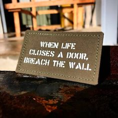 a sign that says when life closes, a door, breach the wall on it