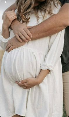 a pregnant woman is holding her husband's belly