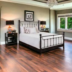 a bedroom with hardwood floors and a bed in the middle is decorated with two lamps on either side of the bed