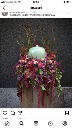 a wooden box filled with flowers and a green vase sitting on top of it's side