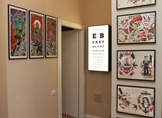 an entry way with pictures on the wall and posters on the walls above it that say eb fazt quinic