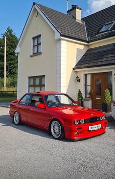 a red car parked in front of a house