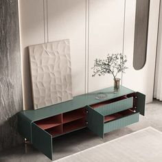 a green table with drawers and a vase on it in front of a white wall