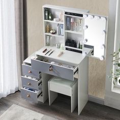 a white vanity with drawers, mirror and lights on the wall next to a window