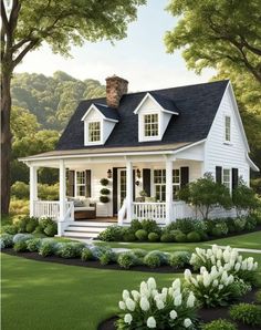 a small white house with black roof and windows on the front porch, surrounded by green grass