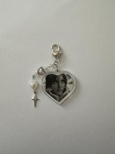 a heart shaped keychain with an image of a woman in the center and a star hanging from it