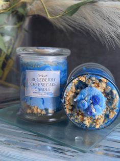 a blueberry cheesecake candle sitting next to a glass jar