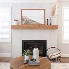 a living room with a fire place and a painting on the wall above it's mantle