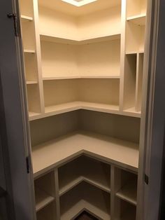 an empty corner closet with shelves in it