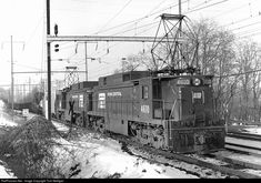 an old black and white photo of a train on the tracks in the winter time