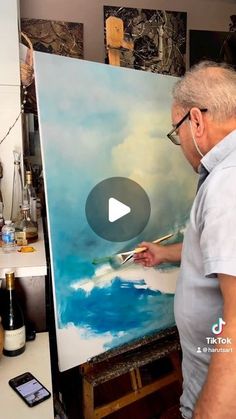 an older man is painting in his studio