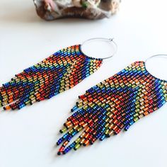 a pair of colorful beaded earrings sitting on top of a table