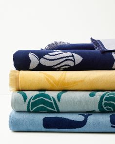 four towels stacked on top of each other in different colors and patterns, with one folded