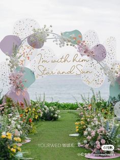 an outdoor wedding ceremony with flowers and umbrellas on the grass by the ocean in hawaii