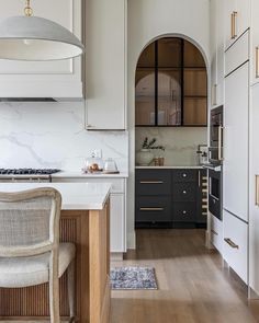 a kitchen with an oven, stove and dining room table in the middle of it