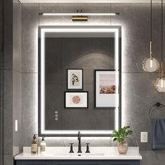 a bathroom vanity with a large mirror above it and lights hanging on the wall next to it