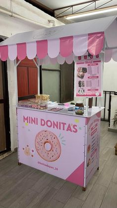 a pink donut kiosk sitting on top of a wooden floor