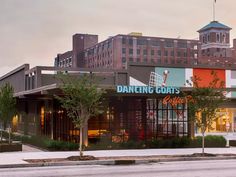 an empty street in front of a building with a sign that says dancing goats on it