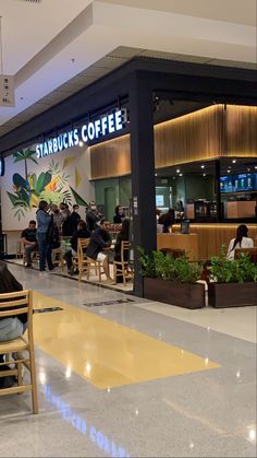 people sitting at tables in a starbucks coffee shop