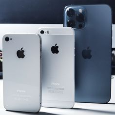 three iphones sitting next to each other in front of a white table with an apple logo on it