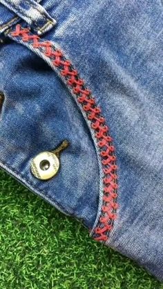 a pair of jeans that have been stitched together and are laying on the grass