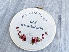 a white embroidered hoop with words on it that says men are tasty but i am a racoon