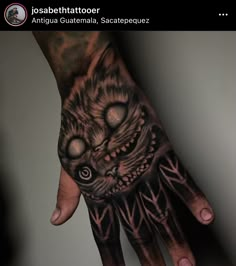 a man's hand with a cat tattoo on it and an eyeball in the middle