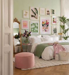 a bedroom decorated in pastel colors with pictures on the wall and pink foot stool