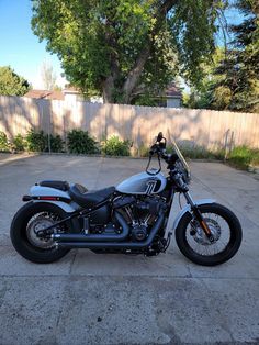 a motorcycle parked in a driveway next to a fence